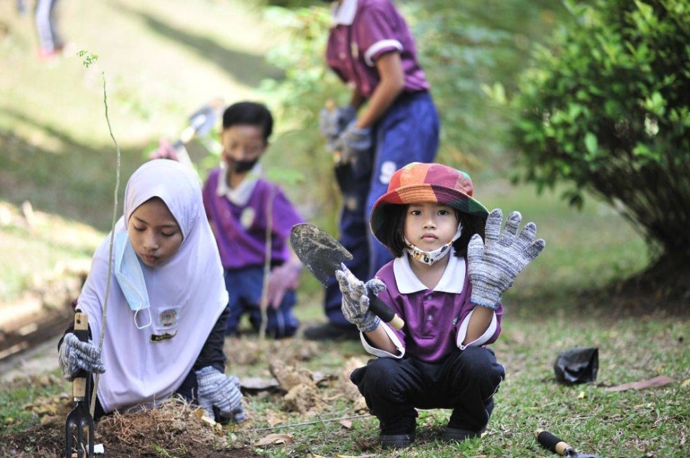 Murid sekolah turut serta dalam program penanaman pokok menerusi inisiatif agenda kelestarian.