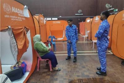Anggota APM Langkawi menyantuni mangsa banjir di PPS Dewan Syifa, Padang Matsirat pada Rabu.
