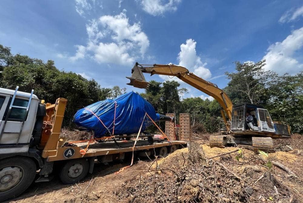 Jengkaut dan lori pengangkut digunakan untuk membawa keluar bangkai helikopter berkenaan dari kawasan nahas di Hutan Simpan Chikus berhampiran Bidor pada Rabu.