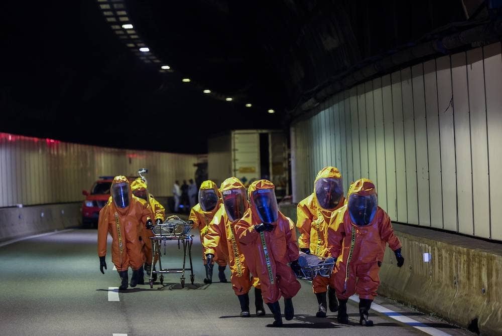 Pasukan Khas Bahan Kimia Berbahaya (Hazmat) Jabatan Bomba dan Penyelamat Malaysia (JBPM) membawa keluar 'mangsa' pada Latihan Ex-Genting 2022 di Terowong Genting Sempah awal pagi Khamis. - Foto Bernama