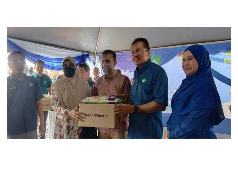 Mohd Salim (dua dari kanan) turut menyerahkan sumbangan kotak makanan MAFI kepada penerima.