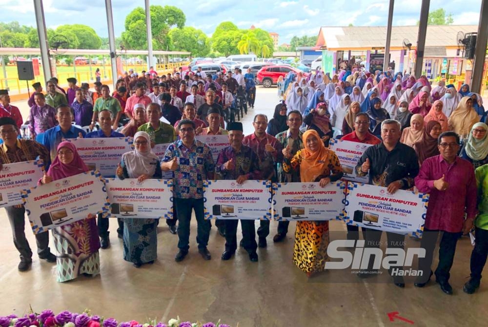 Md Alwi (depan, tiga dari kiri) bersama penerima komputer pada Jelajah Pendidikan Luar Bandar di SMK Kok Lanas, Kota Bharu pada Khamis.