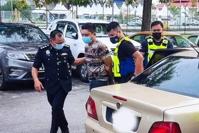 Muhammad Nasyran (dua kiri) diiringi anggota polis menuju ke Mahkamah Majistret di Alor Setar pada Khamis.