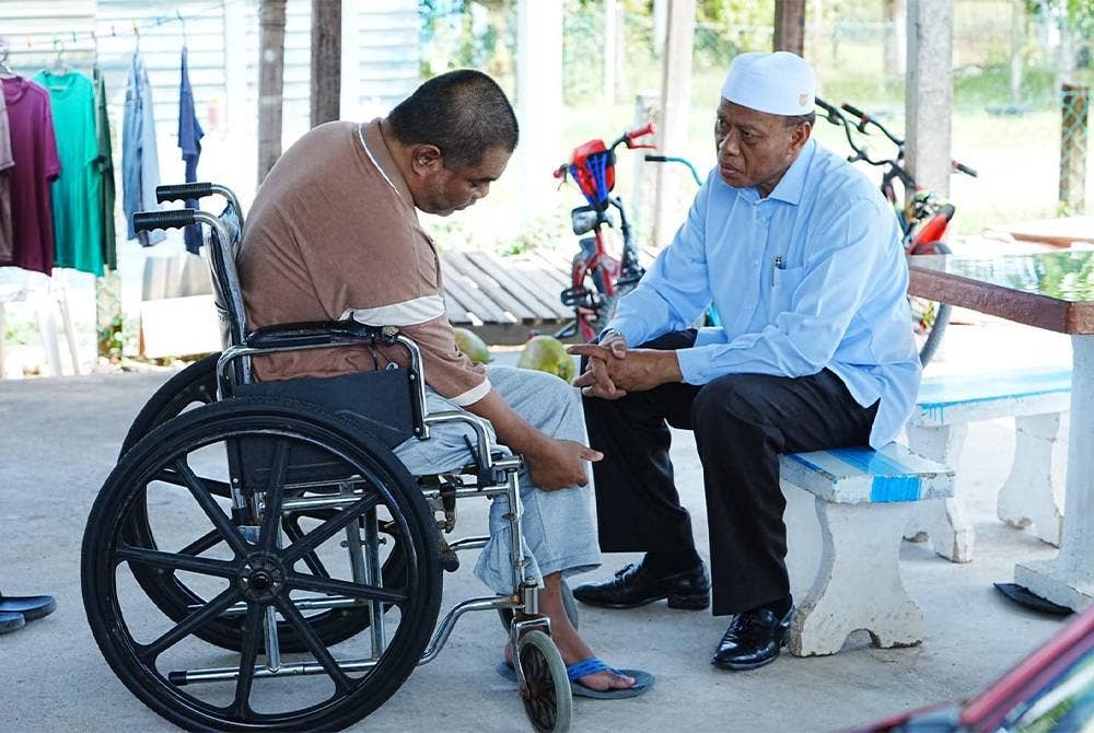 Wan Romai (kanan) semasa Program Ngopi bersama penduduk dan turun padang di Kampung Alor Senibong dalam Parlimen Pokok Sena pada Rabu.