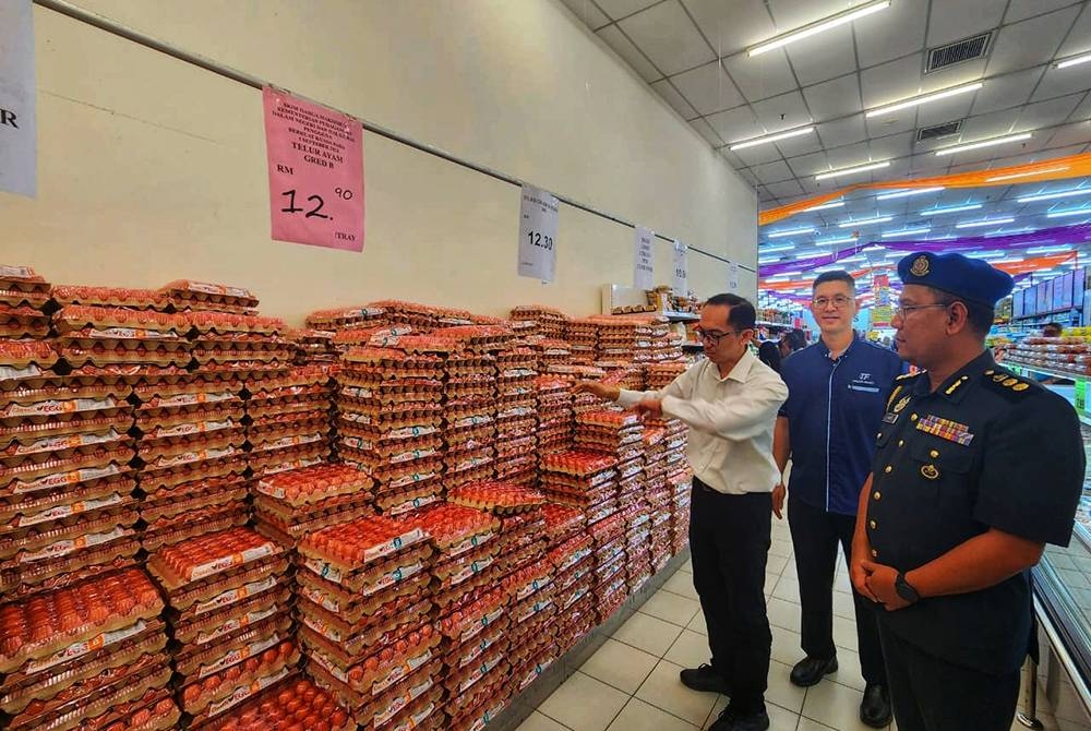 Mark Ujin (kiri) meninjau bekalan telur yang terdapat di sebuah pasar raya di Bentong pada Sabtu.