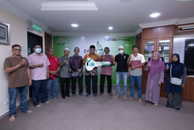 Amran (enam dari kanan) menyerahkan replika kunci kepada penerima bantuan Skim Inapan Kasih.