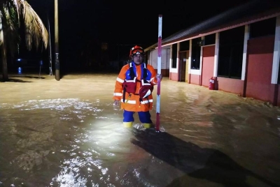 Anggota APM Padang Terap semasa membuat pemantauan banjir kilat di
Kampung Baru Padang Sanai, Kuala Nerang pada malam Jumaat.