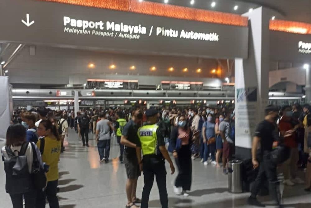 Beberapa pengembara cuba merempuh ketika kawalan dibuat oleh pihak polis bantuan bagi mengehadkan jumlah di lokasi cop pasport.