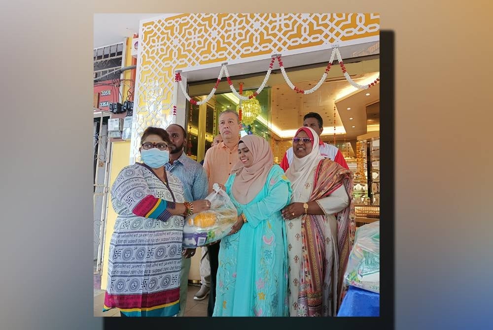 Isteri Mohd Anuar, Datin Siti Aishah Abdullah menyampaikan sumbangan makanan kepada seorang daripada 150 penerima terpilih.