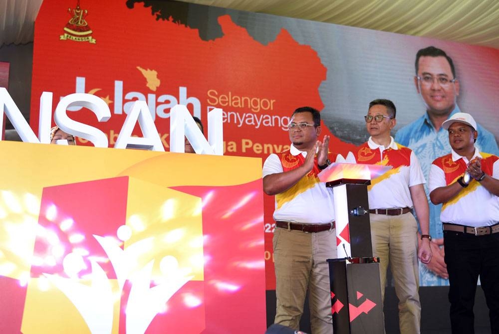 Amirudin (kiri) menyempurnakan pelancaran Skim Insan di Jelajah Selangor Penyayang di Stadium Sultan Suleiman pada Ahad. - Foto Rafeq Redzuan