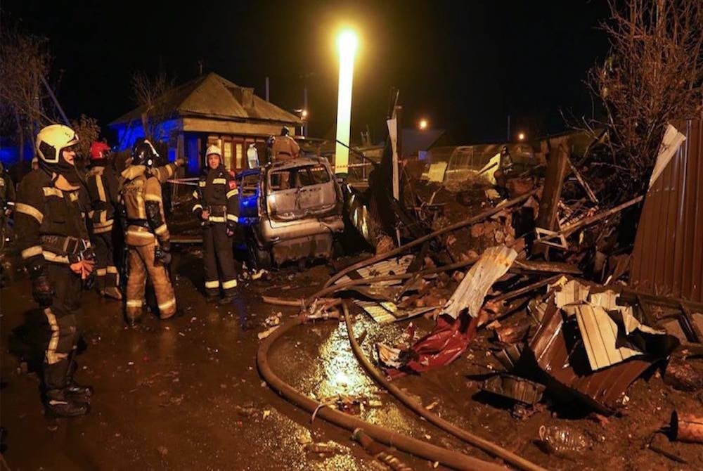 Beberapa anggota penyelamat berada di lokasi dua jet tentera terhempas di rumah dua tingkat di bandar Irkutsk, Siberia pada Ahad. - Foto AP