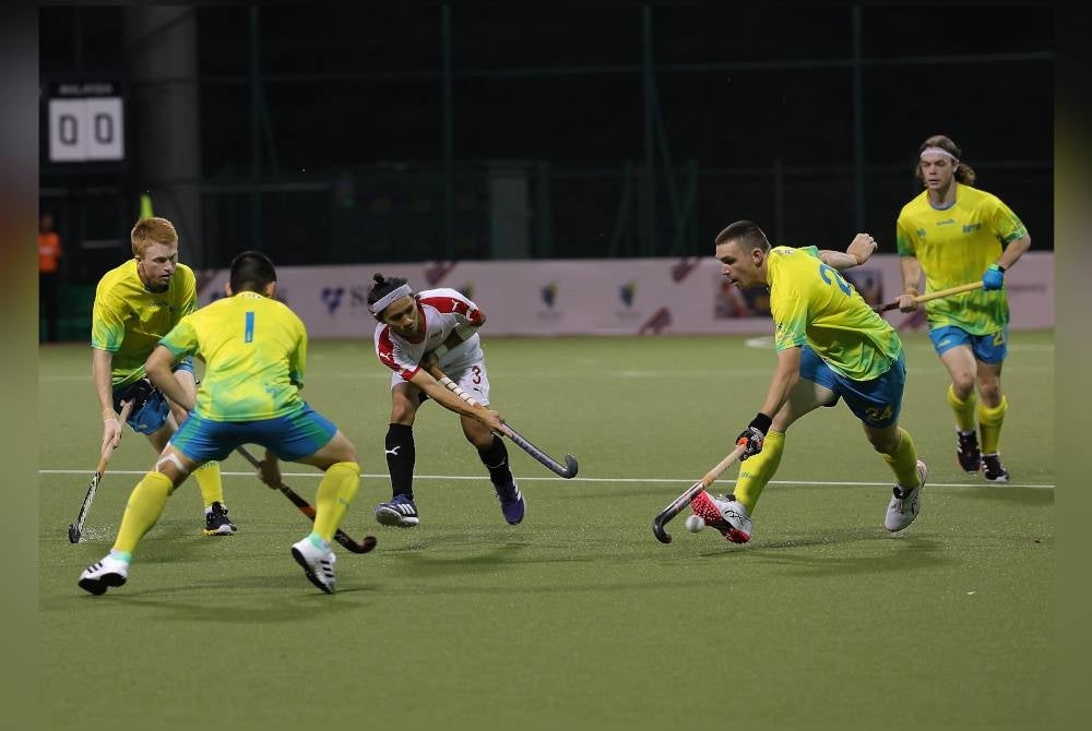 Pemain negara, Alfarico (tengah) cuba melepasi beberapa pemain Australia pada perlawanan Piala Sultan Johor di Stadium Hoki Taman Daya, pada Ahad. - Foto Bernama