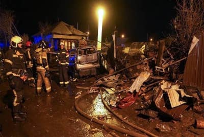 Beberapa anggota penyelamat berada di lokasi dua jet tentera terhempas di rumah dua tingkat di bandar Irkutsk, Siberia pada Ahad. - Foto AP