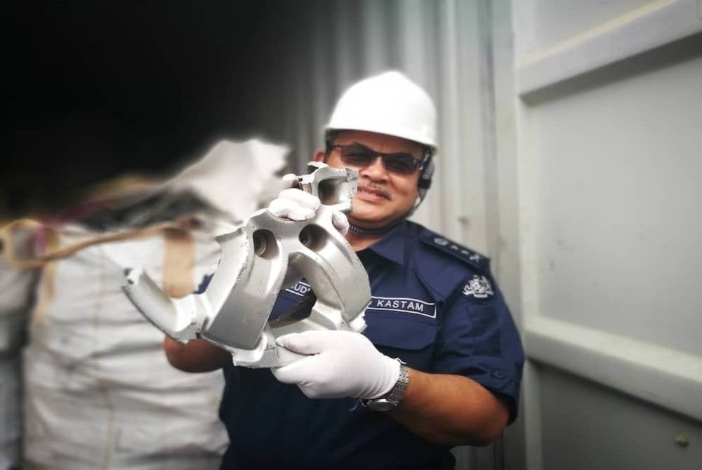 Misbahudin menunjukkan kepingan logam yang masih belum dimampatkan yang turut ditemui dalam salah sebuah kontena yang diperiksa.