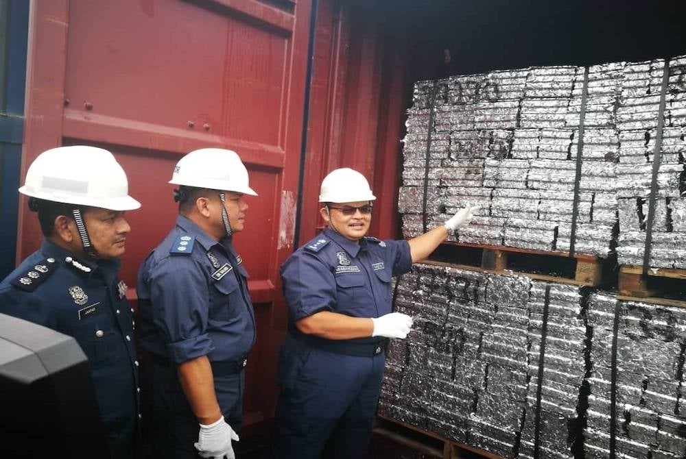 Misbahudin menunjukkan sekerap aluminium yang telah dimampatkan menjadi bongkah aluminium di dalam salah sebuah kontena yang diperiksa.