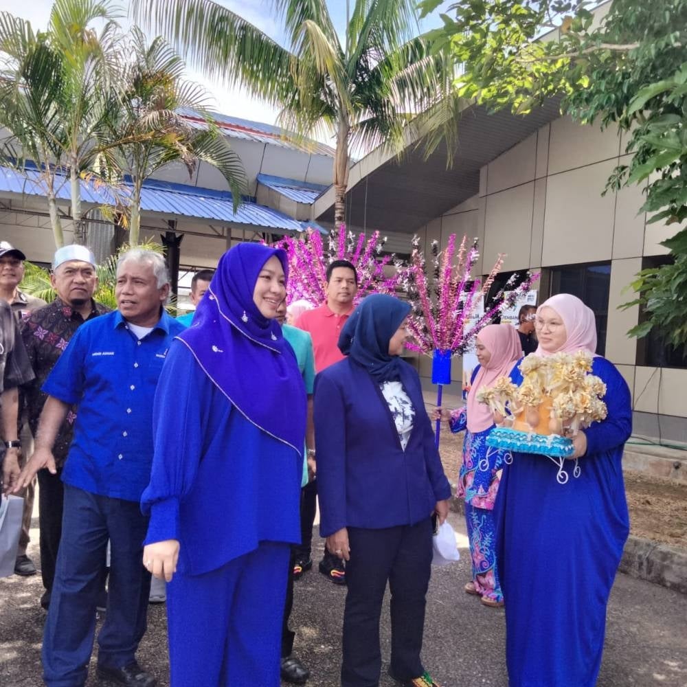 Mohd Adhan (belakang, kanan) mengiringi Fatimah pada majlis perasmian Program Berkhatan Muhibah Bilateral Malaysia-Thailand di Bukit Bunga pada Selasa.