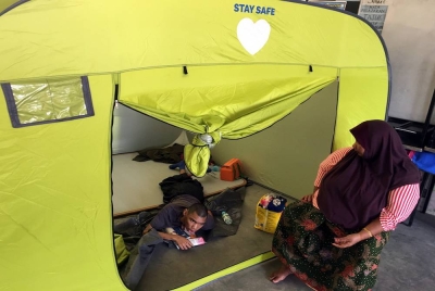 Zaiton Suman, 55, (kanan) bersama anak istimewanya, Muhammad Iman Farhan Abdullah, 17, ditempatkan di PPS Sekolah Kebangsaan Durian Tunggal selepas rumah mereka di Kampung Bukit Tambun dinaiki air. - Foto Bernama