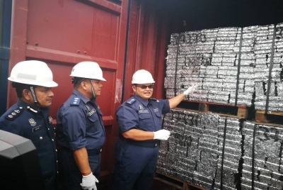 Misbahudin menunjukkan sekerap aluminium yang telah dimampatkan menjadi bongkah aluminium di dalam salah sebuah kontena yang diperiksa.