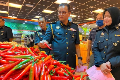 Azman memeriksa cili merah semasa mengadakan pemantauan pematuhan skim harga maksimum musim perayaan Deepavali di sebuah pasar raya di Kota Bharu pada Selasa.