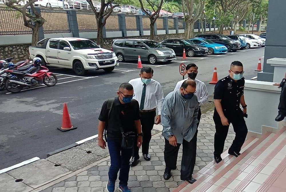 Tertuduh (depan, tengah) ketika hadir di Mahkamah Majistret Seremban pada Rabu.