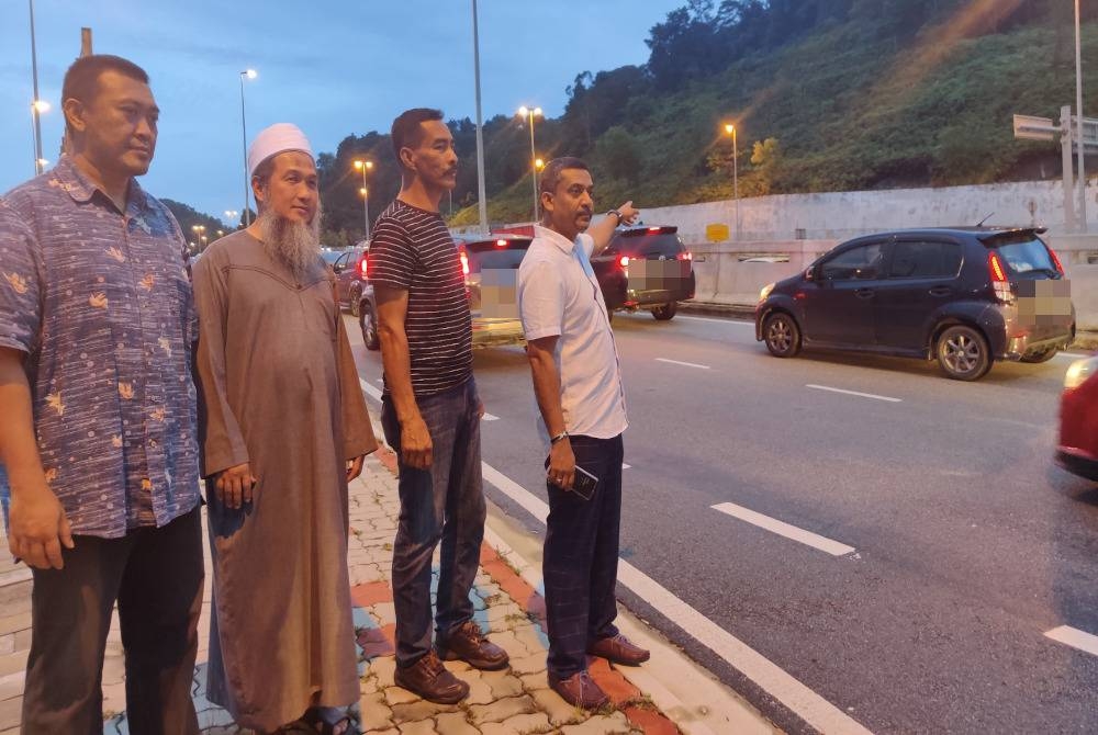 Mohd Shaid (kanan) menunjukkan keadaan aliran trafik sesak pada Rabu.