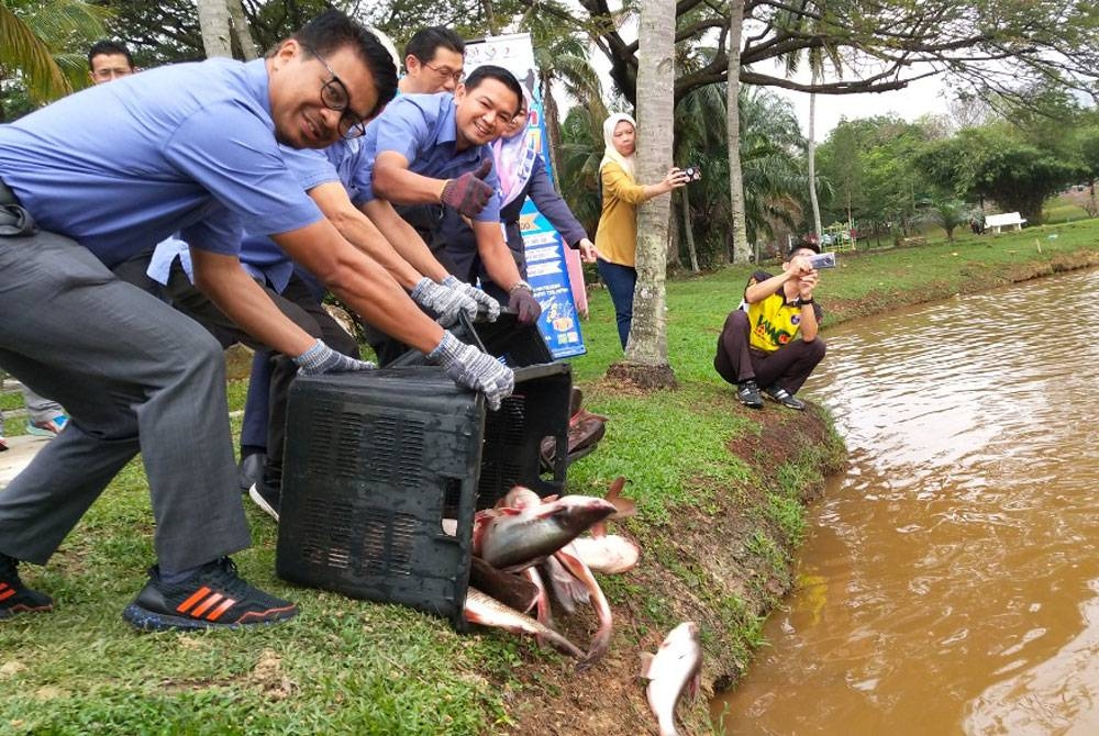 Johary (depan) melepaskan 500 kilogram pelbagai spesis ikan Ahad ini.
