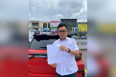 Wei Kiat menunjukkan laporan yang dibuat di Balai Polis Rawang, di sini pada Rabu.