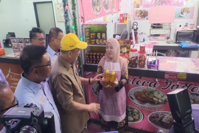 Hajiji mengedarkan minyak masak jenama 'Sayang' keluaran kerajaan negeri kepada peniaga di Anjung Selera, Likas, Kota Kinabalu.
