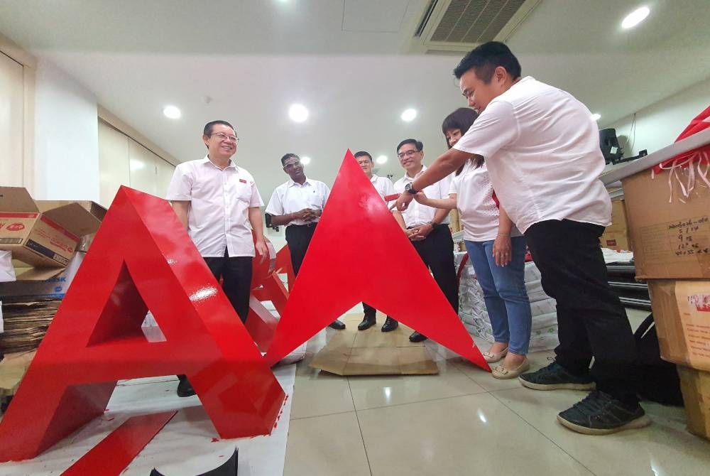 Guan Eng (kiri) melihat persiapan bahan kempen yang sedang dibuat di Wisma DAP Pulau Pinang.