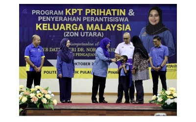 Dr. Noraini menyampaikan replika kad Simpan SSPN Prime kepada murid Kemas sebagai penerima Program Kembara Keluarga Simpan SSPN Peringkat Negeri Pulau Pinang.
