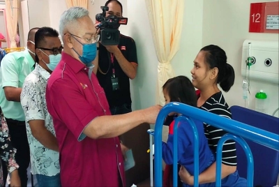 Noh (kiri) menziarahi pesakit semasa melakukan lawatan ke Hospital Tanjong Karang pada Khamis.