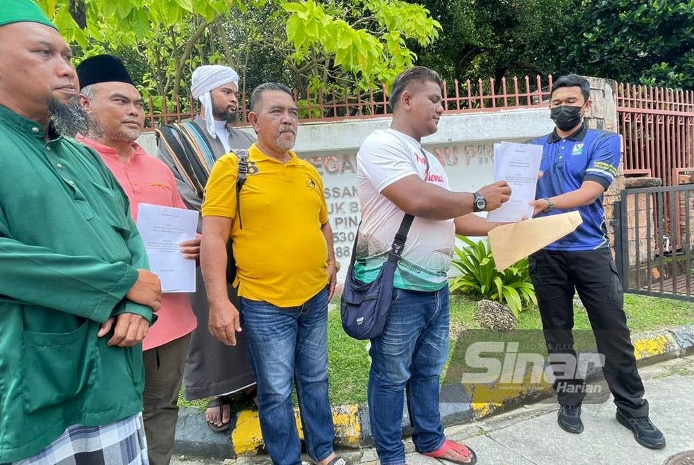 Mohamad Afizee (dua dari kanan) menyerahkan memorandum kepada wakil Taman Negara Pulau Pinang pada Jumaat.