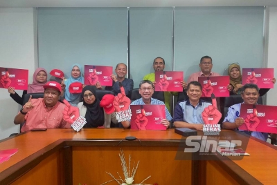 Badlishah (duduk, tengah) bersama petugas pasukan Rasuah Busters dan pegawai Ikram di Seri Kembangan pada Jumaat.