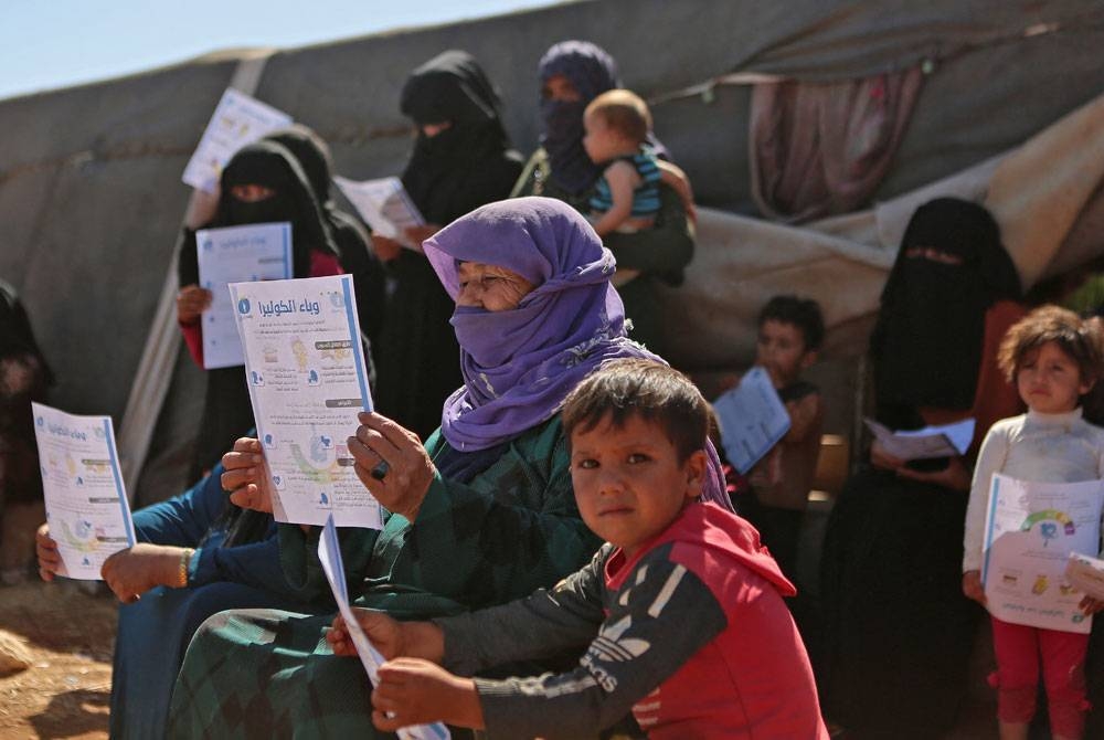 Penduduk Syria mengambil bahagian dalam kempen kesedaran penyakit taun di kem pelarian di Sarmada, Syria. - Foto AFP