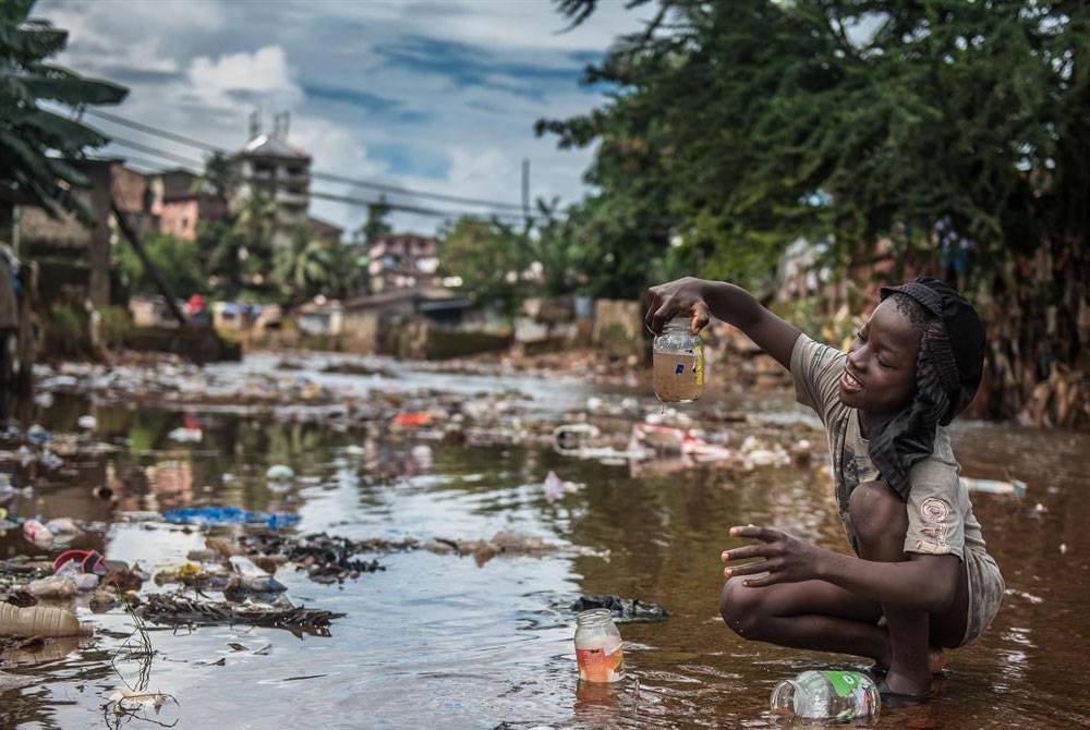 Kanak-kanak sedang bermain air tercemar yang dikhuatiri mengandungi bakteria taun. - Foto Agensi