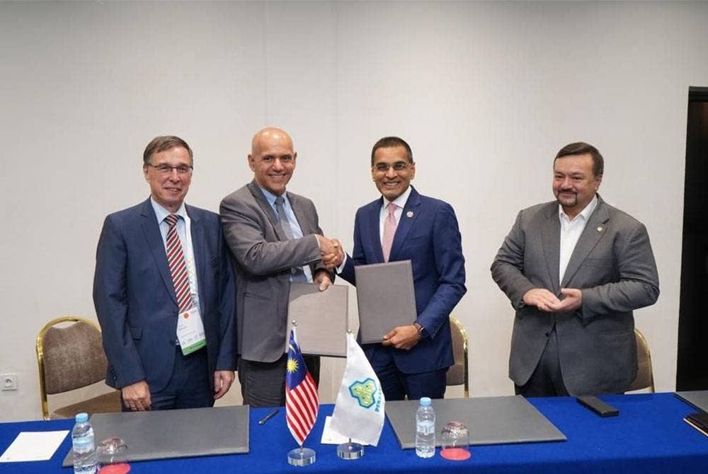 Mohammed Azman (dua dari kanan) bertukar dokumen dengan wakil ISSA.