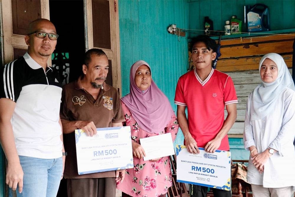 Apli (kiri) ketika menyerahkan Bantuan Pengajian KPT-PTPTN Prihatin berjumlah RM500 kepada penerima yang bermula sejak 8 Oktober lalu.