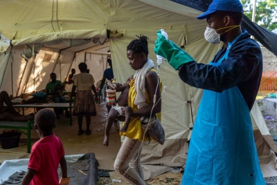 Seorang wanita membawa anaknya yang mempunyai gejala taun di klinik dikendalikan Doctors Without Borders di Port-au-Prince, Haiti. - Foto AFP