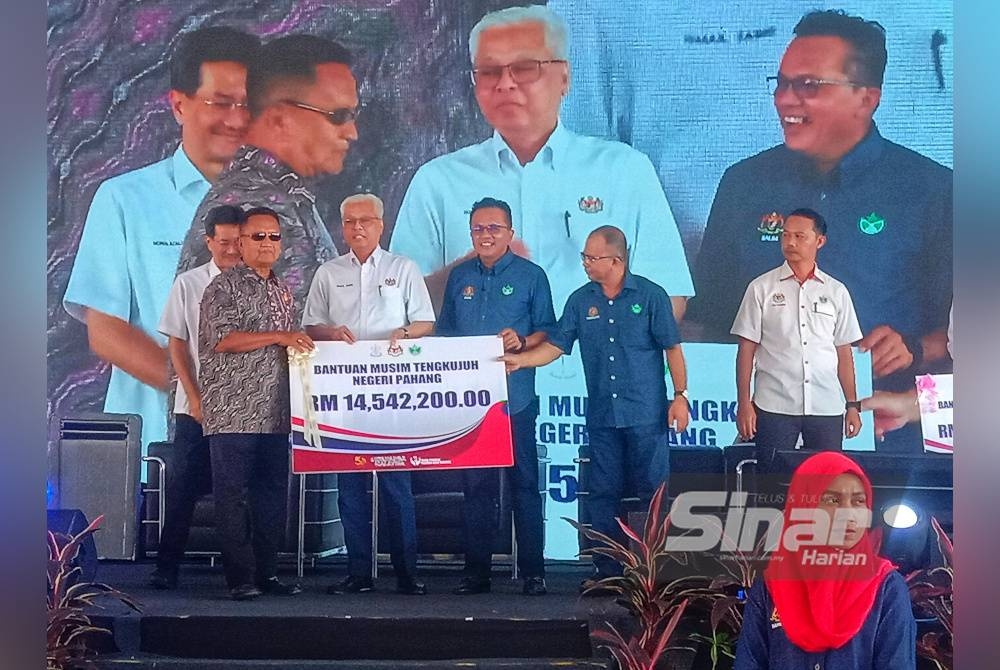 Ismail Sabri (empat dari kanan) menyampaikan replika cek BMT bernilai RM14.54 juta untuk pekebun kecil di Pahang.