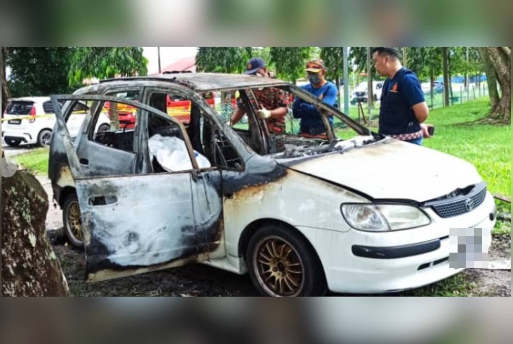 Anggota bomba memeriksa kenderaan yang terbakar dalam kejadian di Taman Iramas, Kolombong, Kota Kinabalu.