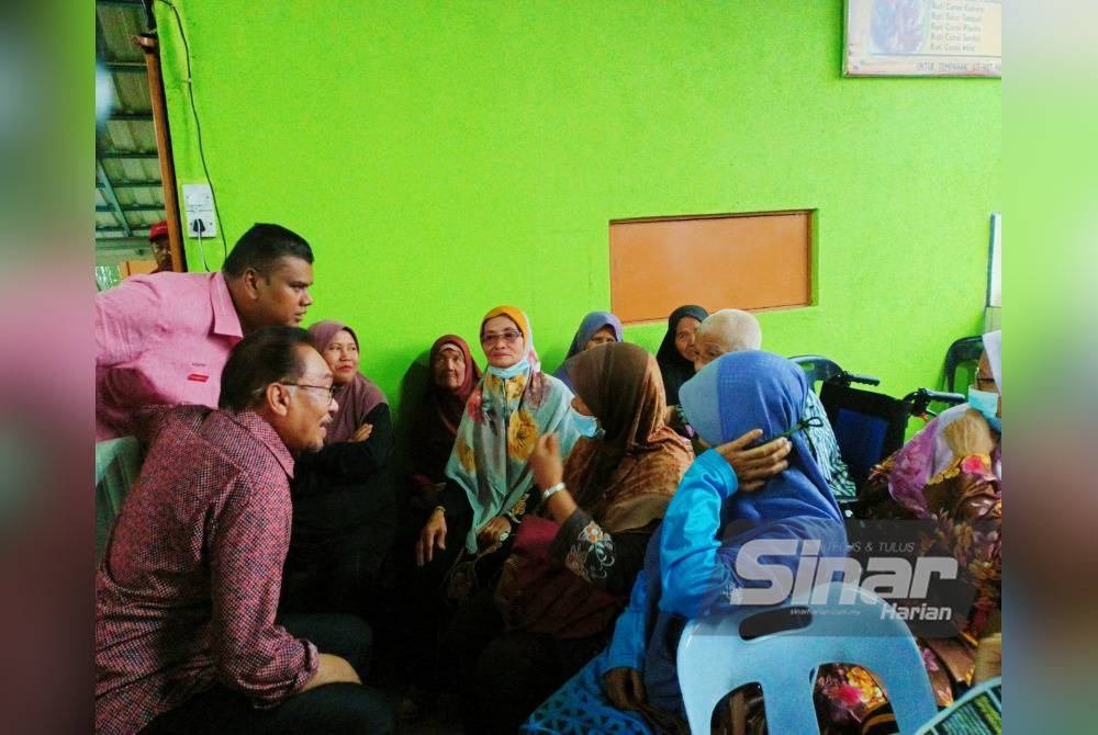 Anwar yang umum bertanding di Parlimen Tambun pada PRU15 menyantuni pengundi di Kampung Ulu Chemor di sini pada Ahad.