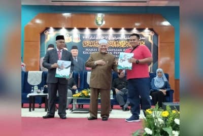Mohd Amar (dua dari kanan) menyampaikan hadiah kepada wakil pelajar pada Majlis Penyampaian Anugerah Kecemerlangan Peperiksaan 2021 Kerajaan Negeri Kelantan pada Isnin.