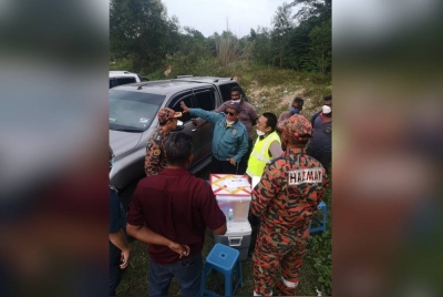 Pasukan bomba bersama pegawai JAS menyiasat berhubung penemuan 33 tong berisi sisa buangan terjadual di Gopeng. - Foto Ihsan bomba