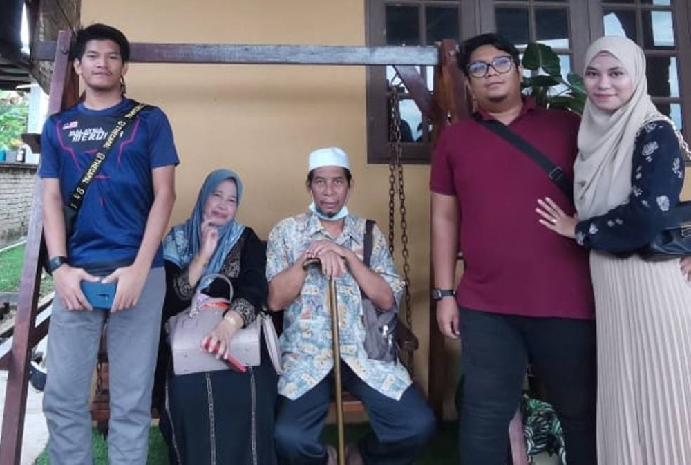 Muhammad Hafiz (kiri) bersama arwah bapanya, Mokhtar (tengah) ketika tiba di sebuah rumah inap di Ajil, Hulu Terengganu pada hari pertama sampai di Terengganu, Ahad lalu.