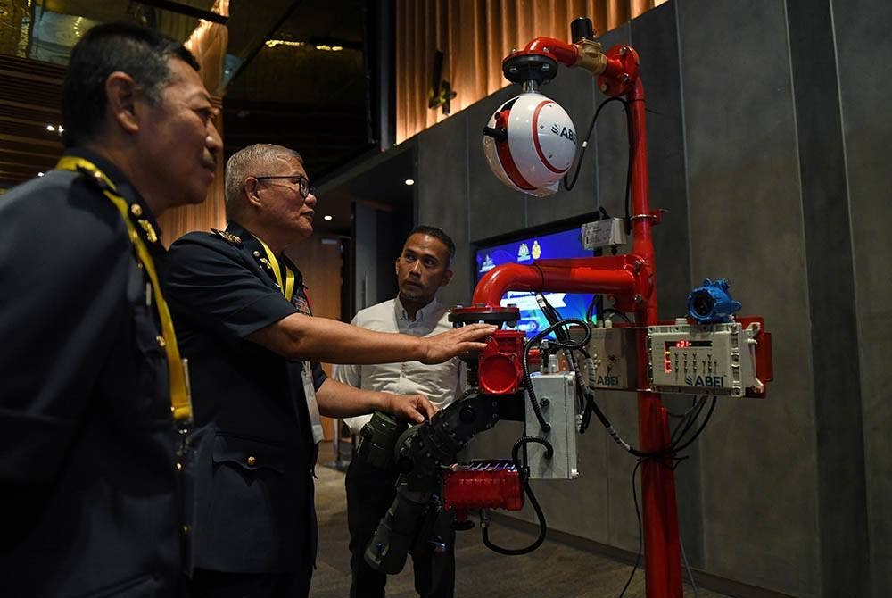 Mohammad Hamdan (dua dari kiri) melihat peralatan Automatic Fire Monitor 1200/1800 Series jenis Abei yang dipamerkan pada Seminar Undang - Undang Kecil Bangunan Seragam (Pindaan 2021) Peringkat Zon Utara, Jabatan Bomba dan Penyelamat pada Selasa. - Foto Bernama