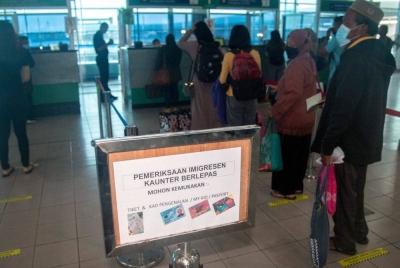 Para penumpang bot laju beratur di kaunter imigresen di balai pelepasan Terminal Feri Antarabangsa Labuan. - Foto Bernama