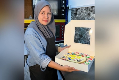 Marlia menunjukkan hasil dekorasi kuih tart keju di kedai kek miliknya dekat Taman Wira Perdana pada Selasa. - Foto Bernama