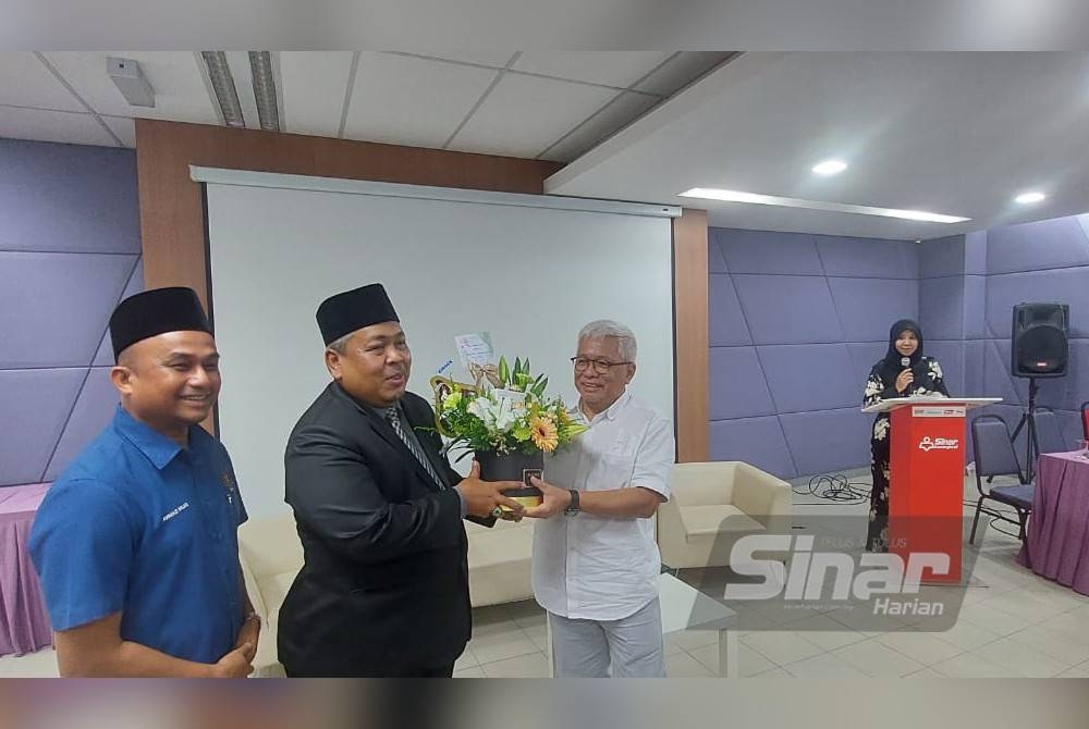 Hussamuddin (paling kanan) menyampaikan cenderahati kepada Ketua Penolong Setiausaha Regulatori Al-Quran dan Hadis KDN, Dr Mohd Zamir Bahall.