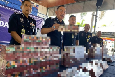 Muhamad Zaki (dua dari kiri) menunjukkan sebahagian daripada rokok seludup yang dirampas semasa sidang akhbar di IPK Kelantan, Kota Bharu pada Rabu.