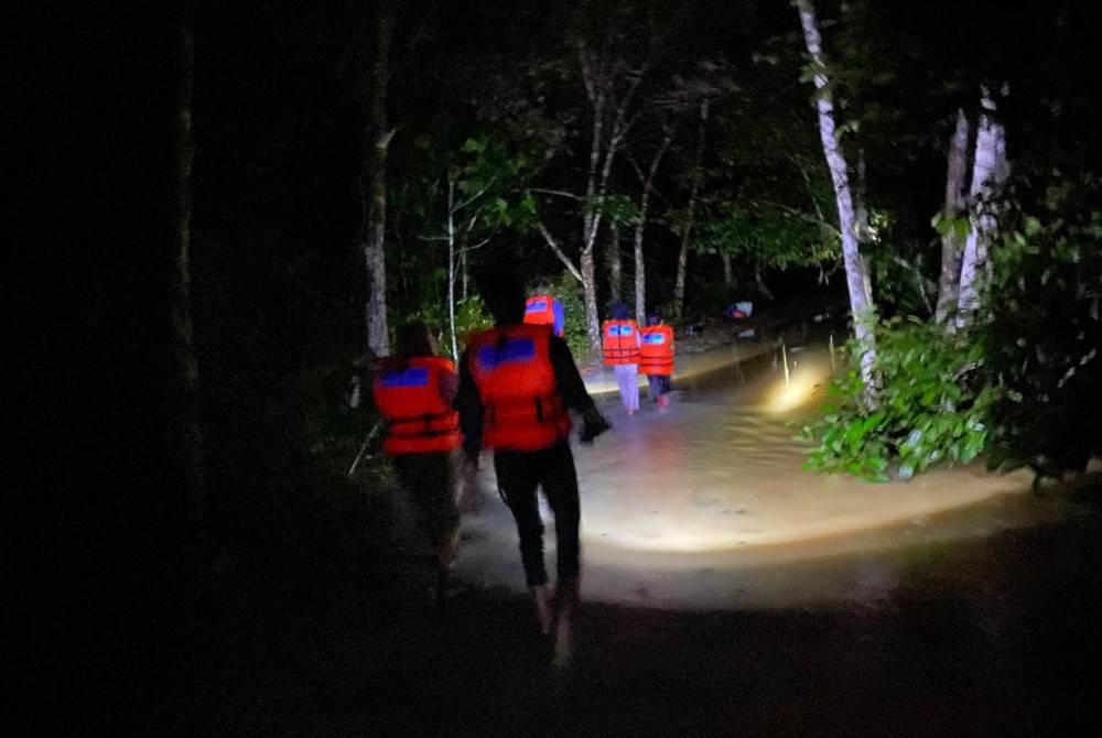 Anggota APM membantu memindahkan mangsa banjir ke salah sebuah PPS yang di buka di Raub pada Khamis.